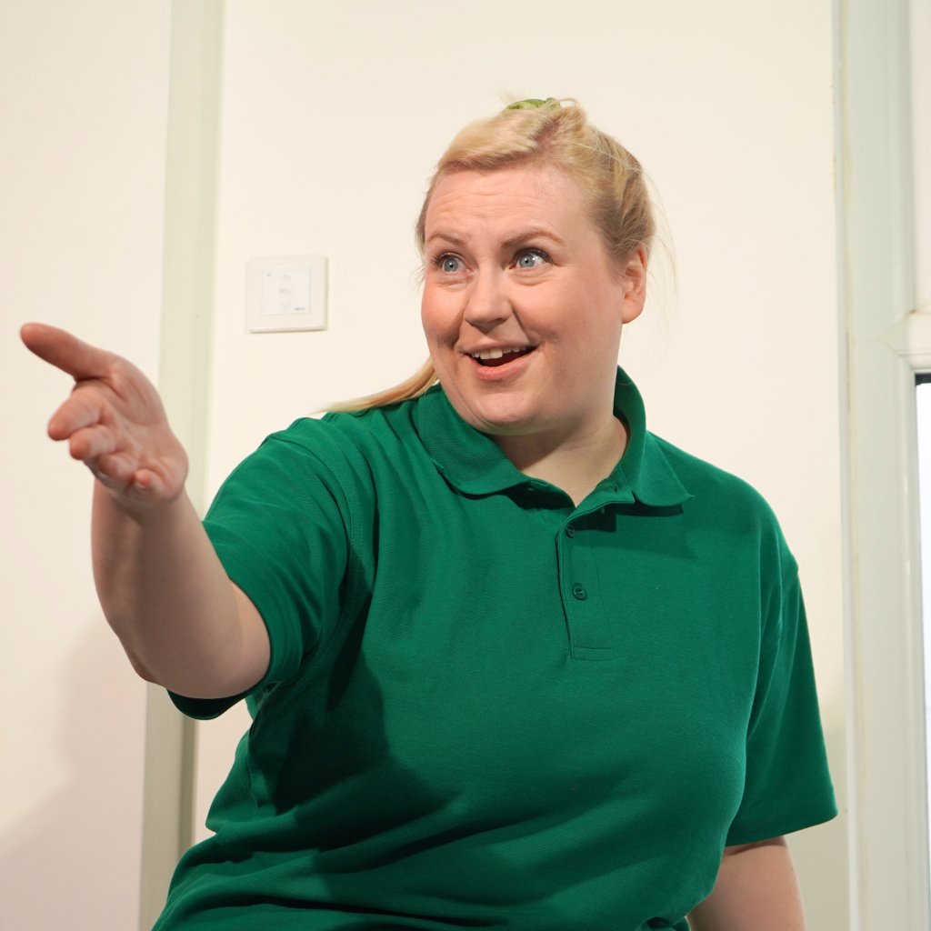 A woman in a green shirt leading a workshop