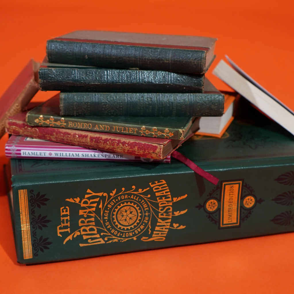 A stack of books labelled as 'The Library Shakespeare', 'Hamlet', 'Romeo and Juliet' and other works. 